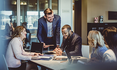 Employees interacting at a table during a meeting